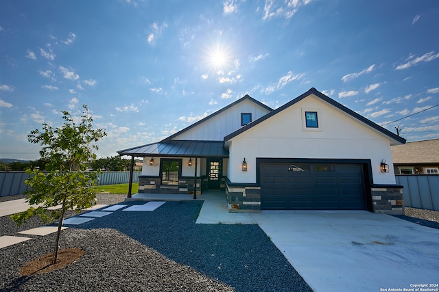 modern inspired farmhouse with a garage and covered porch