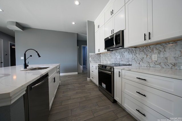 kitchen with light stone counters, electric range oven, dishwashing machine, backsplash, and sink