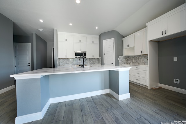 kitchen with sink, tasteful backsplash, white cabinetry, and light hardwood / wood-style floors