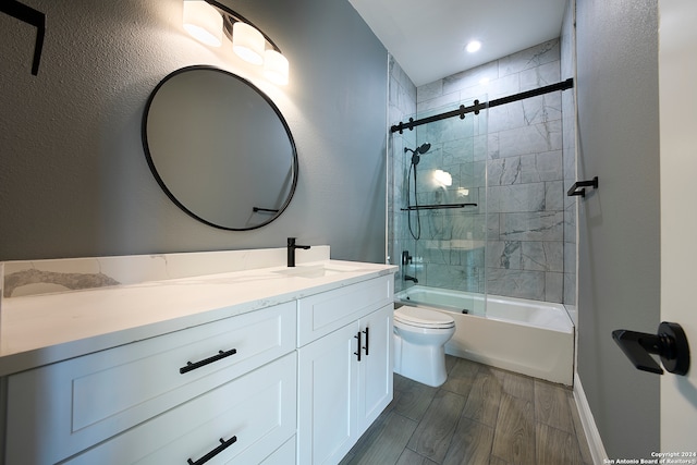 full bathroom featuring wood-type flooring, vanity, toilet, and shower / bath combination with glass door