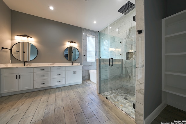 bathroom featuring double sink vanity, hardwood / wood-style flooring, and a shower with shower door