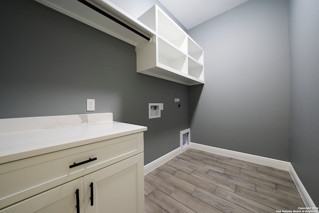 laundry room with cabinets, light wood-type flooring, gas dryer hookup, and washer hookup