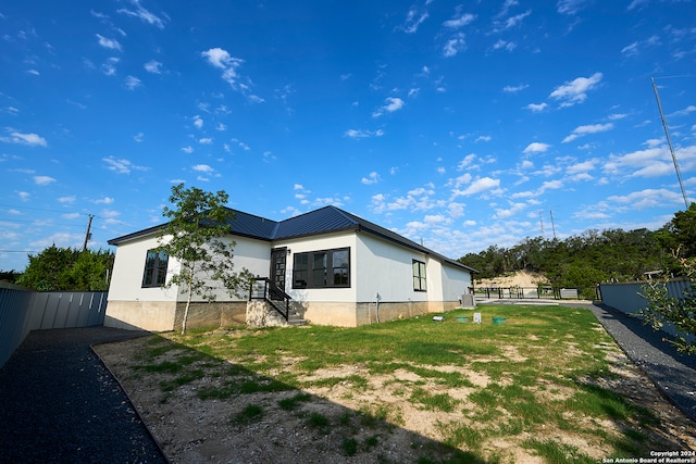 rear view of house featuring a lawn