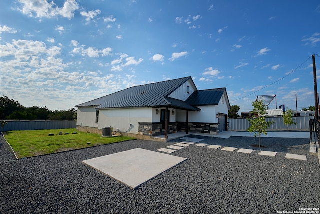 rear view of property with a lawn and a patio