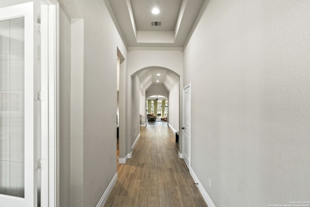 corridor featuring hardwood / wood-style floors and a tray ceiling