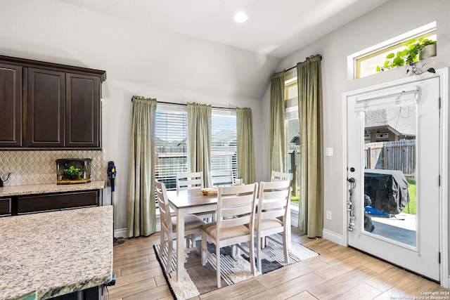 dining room featuring light hardwood / wood-style flooring, a wealth of natural light, and lofted ceiling