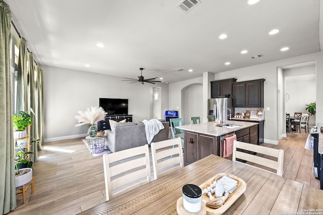 dining space with ceiling fan, sink, and light hardwood / wood-style floors