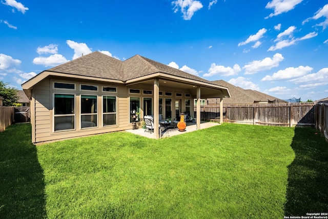 rear view of property featuring a patio and a yard