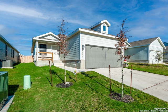 view of front of property featuring cooling unit, a front yard, and a garage