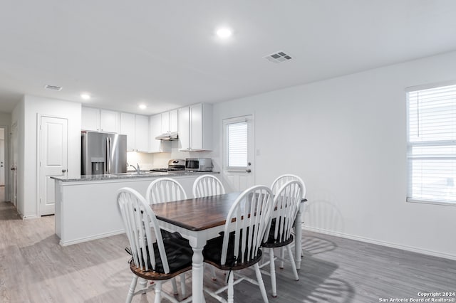 dining space featuring light wood-type flooring and a wealth of natural light