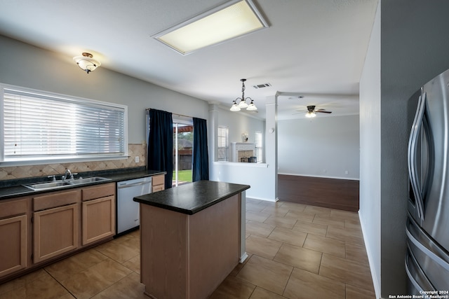 kitchen featuring light tile patterned floors, sink, a center island, and backsplash