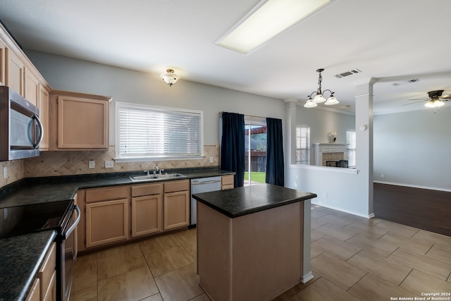 kitchen with appliances with stainless steel finishes, ceiling fan with notable chandelier, a wealth of natural light, and decorative backsplash