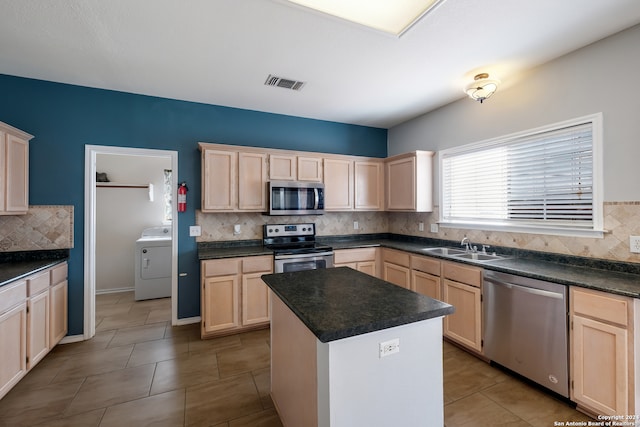 kitchen with tasteful backsplash, washer / dryer, appliances with stainless steel finishes, and tile patterned floors