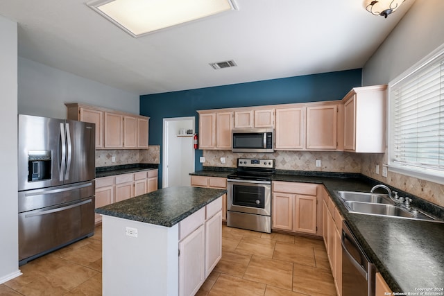 kitchen featuring appliances with stainless steel finishes, sink, light tile patterned floors, and decorative backsplash