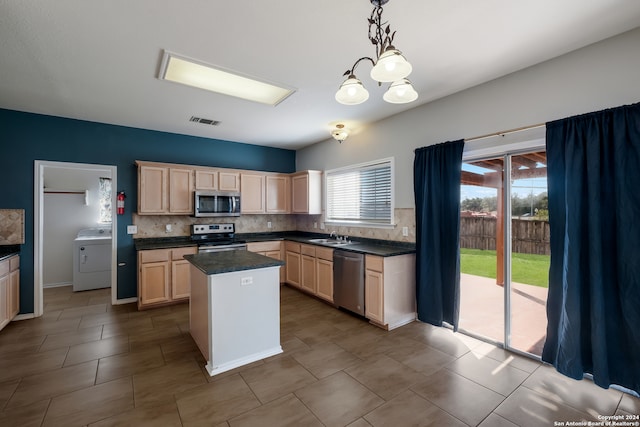 kitchen with decorative backsplash, dishwasher, stove, washer / dryer, and a center island