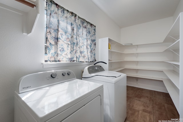 laundry area featuring dark tile patterned flooring and washing machine and clothes dryer