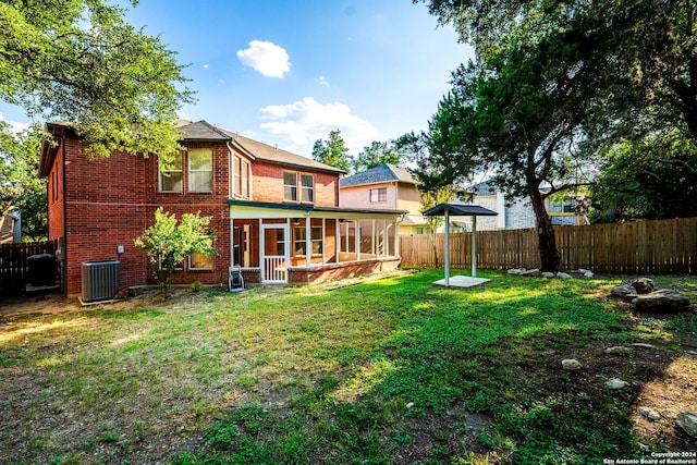 exterior space featuring central AC, a lawn, and a sunroom