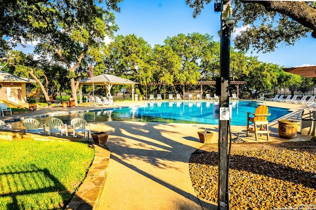 community pool with a gazebo, a patio area, and fence