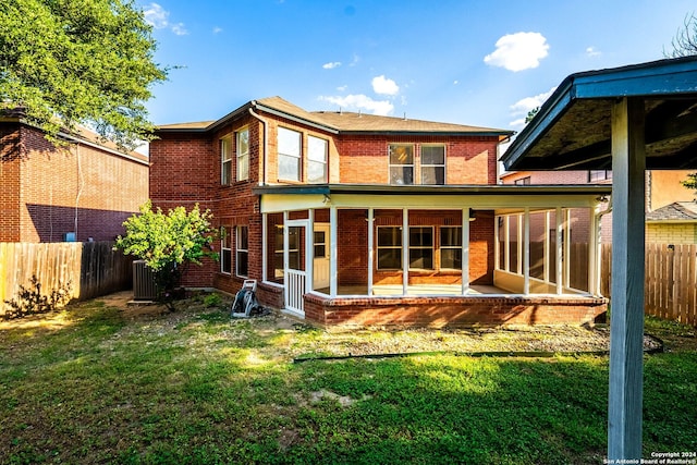 back of house featuring a sunroom, fence, and brick siding