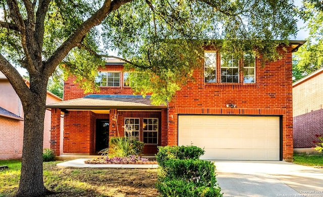 traditional-style home with driveway, an attached garage, and brick siding