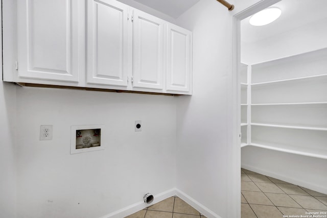 laundry room featuring electric dryer hookup, hookup for a washing machine, light tile patterned floors, and cabinets