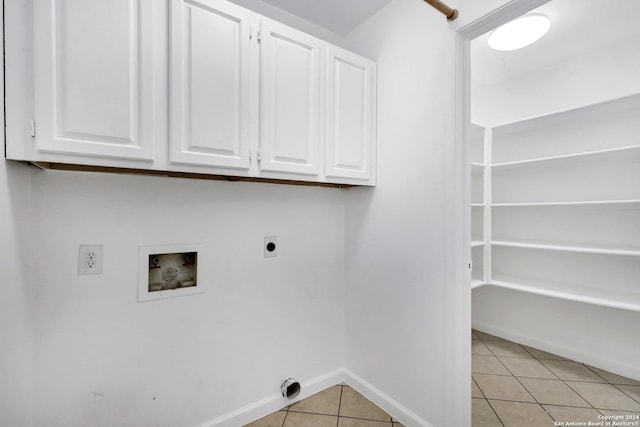 clothes washing area with cabinet space, light tile patterned floors, baseboards, washer hookup, and electric dryer hookup