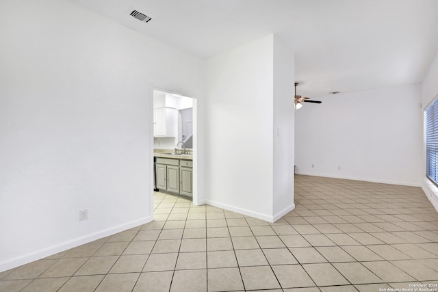 unfurnished room with ceiling fan, light tile patterned floors, and sink