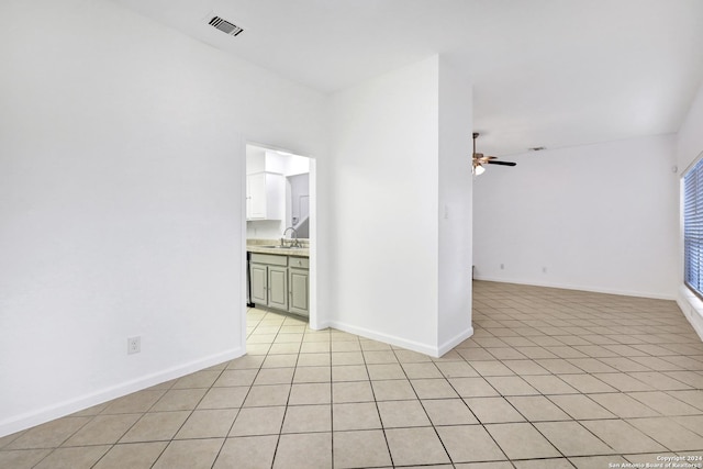 unfurnished room with baseboards, visible vents, a ceiling fan, a sink, and light tile patterned flooring