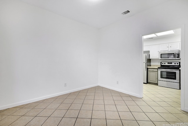 interior space with light tile patterned flooring, white cabinets, and stainless steel appliances