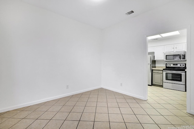 unfurnished room with light tile patterned floors, visible vents, and baseboards