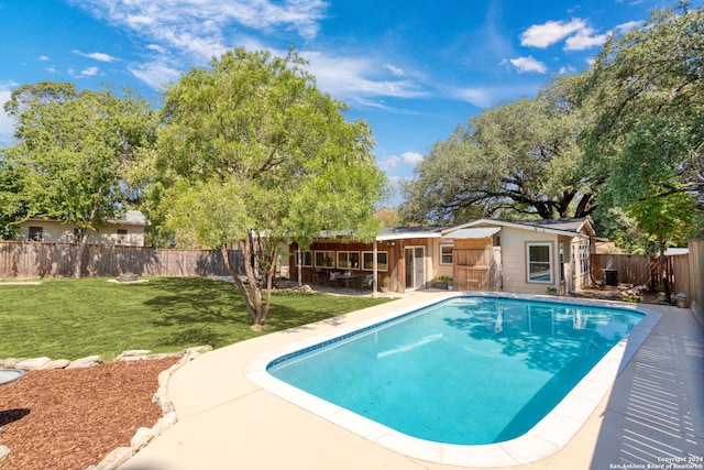 view of pool featuring a lawn