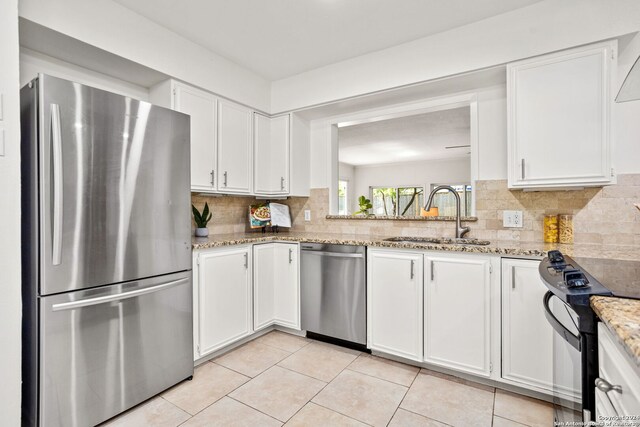 kitchen featuring white cabinetry, kitchen peninsula, island exhaust hood, dishwasher, and light stone countertops