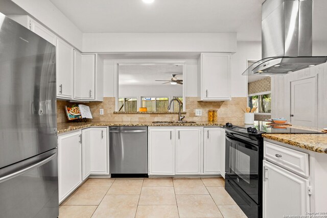 kitchen featuring light stone countertops, light wood-type flooring, stainless steel fridge, and island exhaust hood