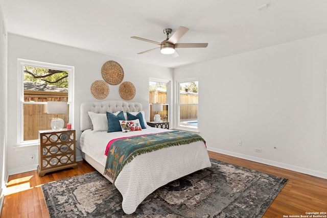 bedroom with ceiling fan, hardwood / wood-style flooring, and multiple windows