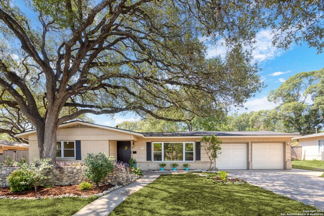 single story home featuring a garage and a front lawn