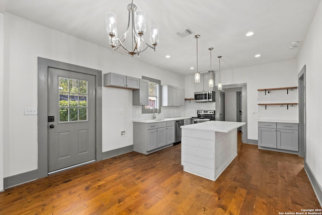 kitchen featuring appliances with stainless steel finishes, dark hardwood / wood-style flooring, a center island, and gray cabinets