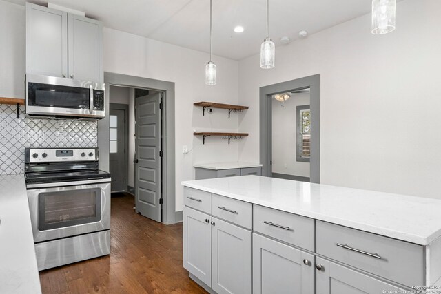 kitchen with dark wood-type flooring, pendant lighting, decorative backsplash, appliances with stainless steel finishes, and gray cabinetry