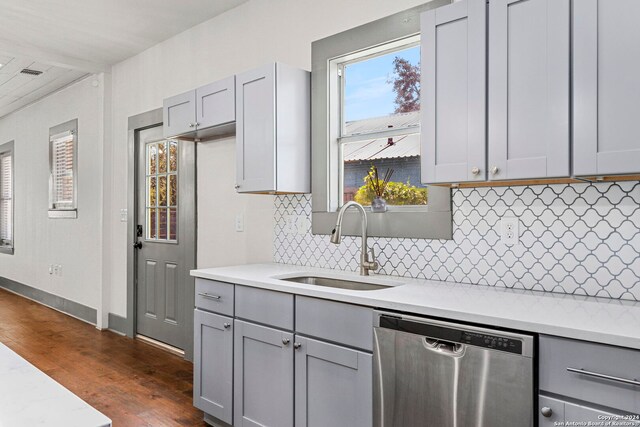 kitchen featuring gray cabinetry, backsplash, dark hardwood / wood-style floors, and dishwasher