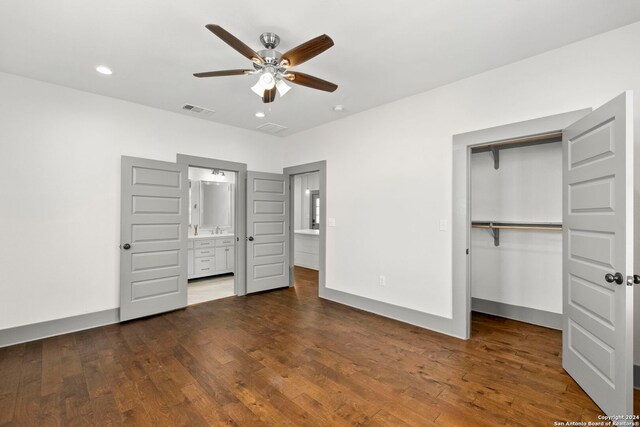 unfurnished bedroom featuring ceiling fan, wood-type flooring, ensuite bathroom, and a closet