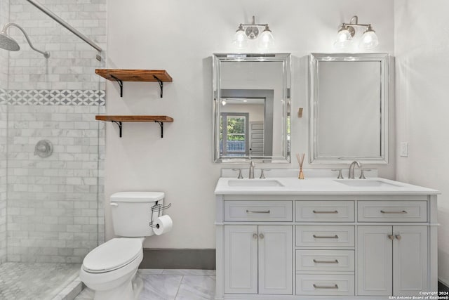 bathroom with tiled shower, toilet, dual bowl vanity, and tile patterned flooring