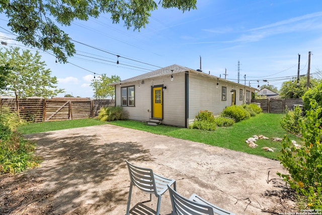 rear view of property featuring a patio area and a lawn