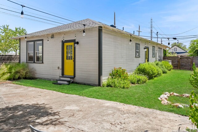 rear view of house with a patio and a lawn