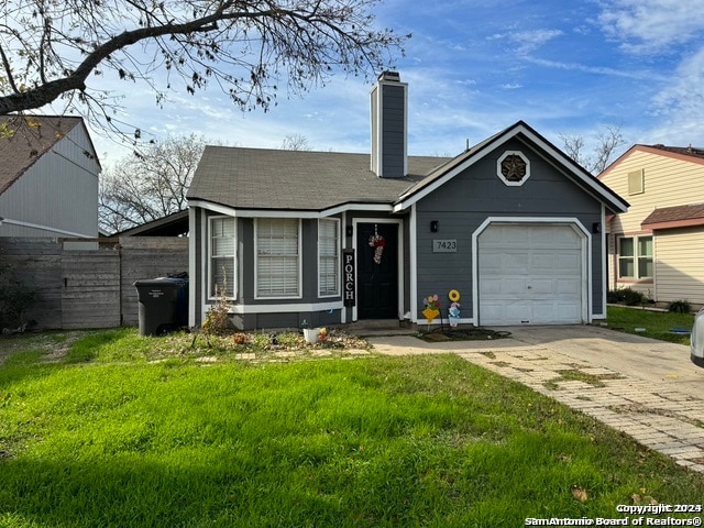 view of front of property with a garage and a front lawn