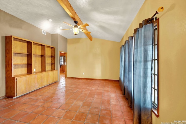 tiled spare room featuring vaulted ceiling with beams, a textured ceiling, and ceiling fan