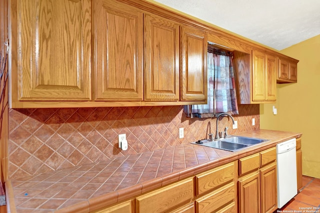 kitchen with tile counters, dishwasher, backsplash, light tile patterned floors, and sink