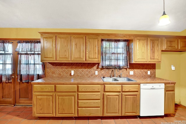 kitchen featuring light tile patterned flooring, tile counters, dishwasher, sink, and decorative backsplash