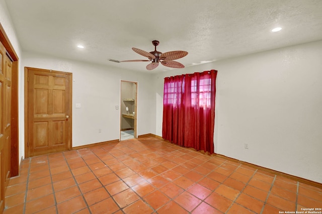 tiled spare room with ceiling fan and a textured ceiling