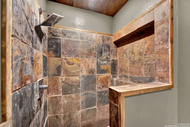 bathroom featuring a tile shower and wooden ceiling