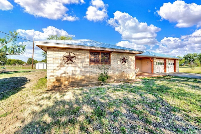 ranch-style home with a front lawn and an outbuilding