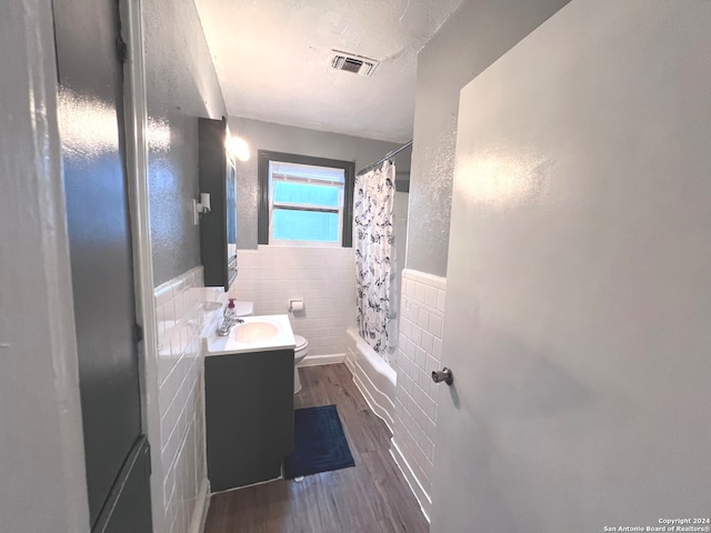 full bathroom featuring toilet, tile walls, shower / bath combination with curtain, backsplash, and vanity